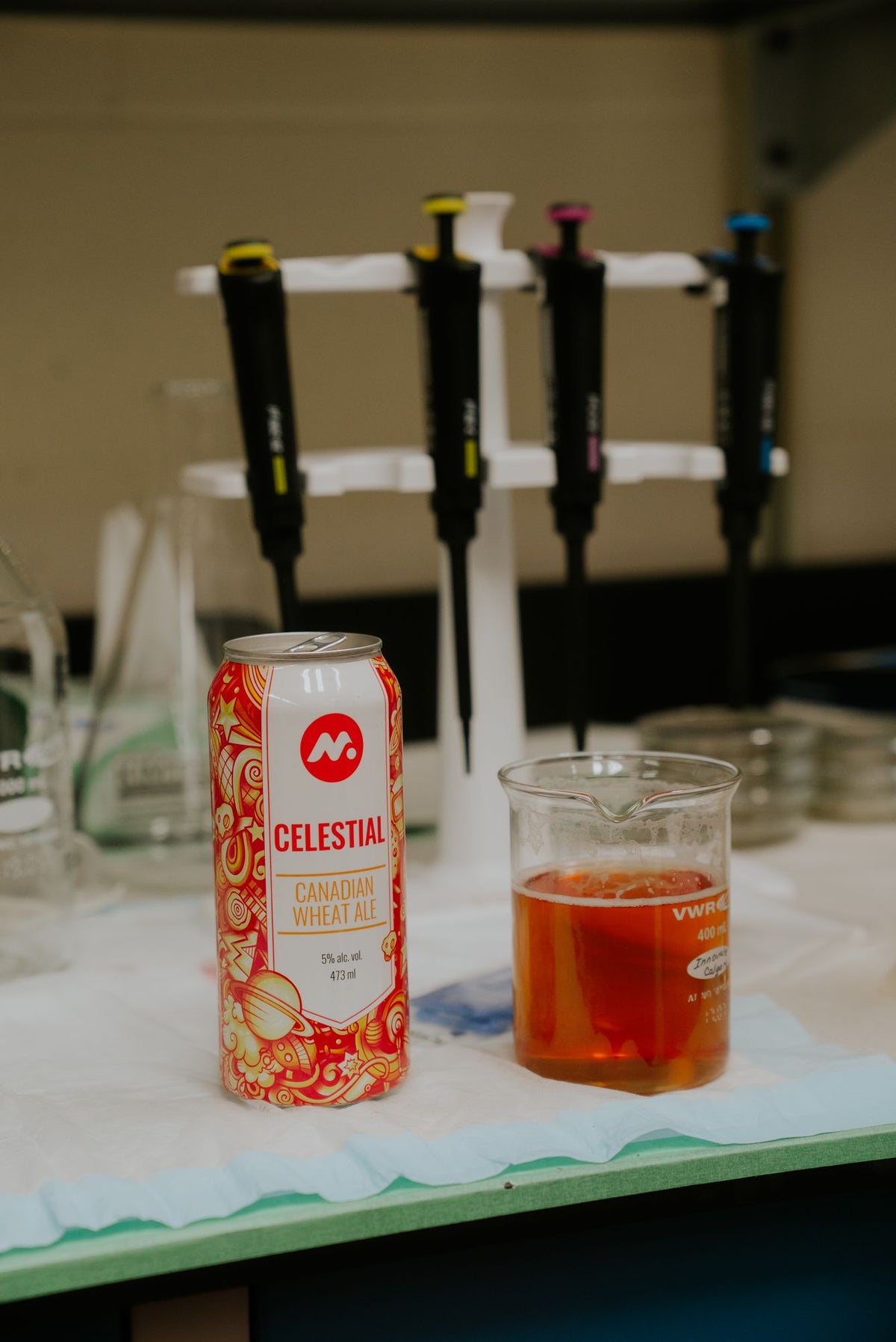 A Celestial can beside a beaker of beer in the quality lab